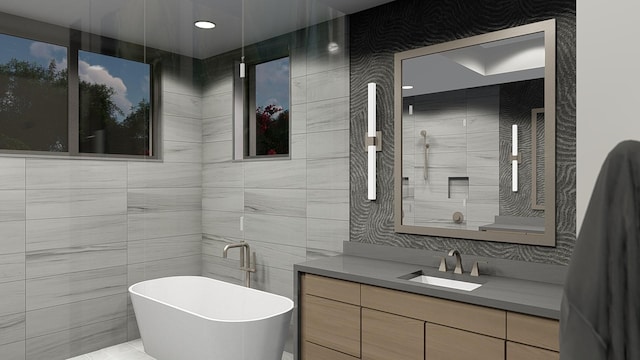 bathroom with a washtub, vanity, and tile walls