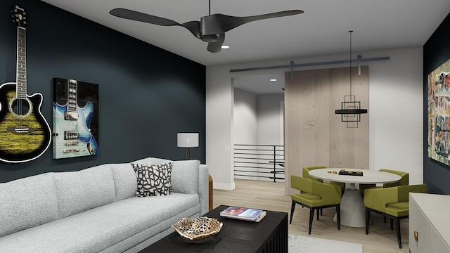 living room featuring a barn door, ceiling fan, and light wood-type flooring