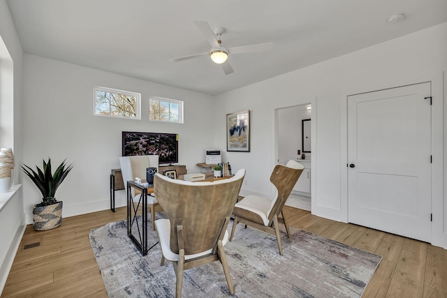 dining space with light hardwood / wood-style flooring and ceiling fan