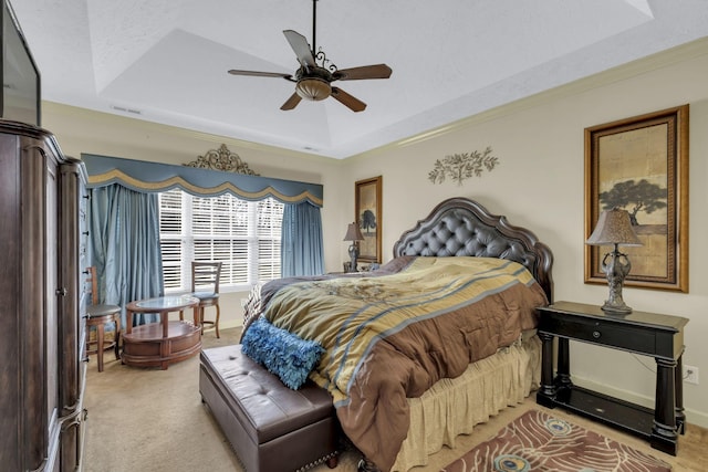 carpeted bedroom featuring ceiling fan and a raised ceiling