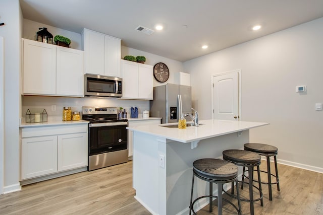 kitchen with white cabinets, sink, an island with sink, and appliances with stainless steel finishes