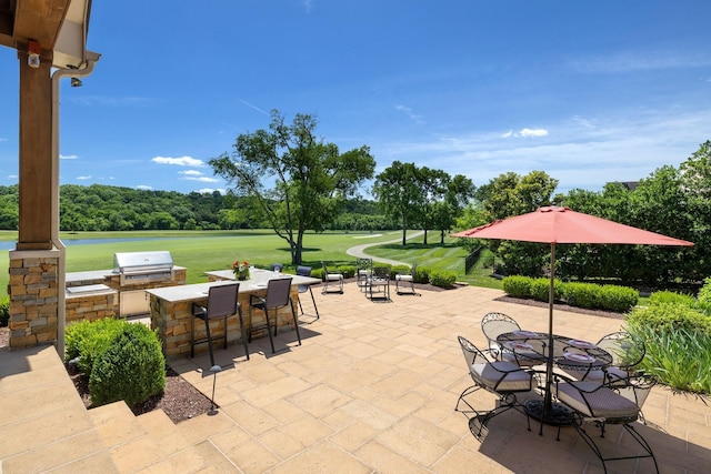 view of patio with a bar, a grill, and exterior kitchen