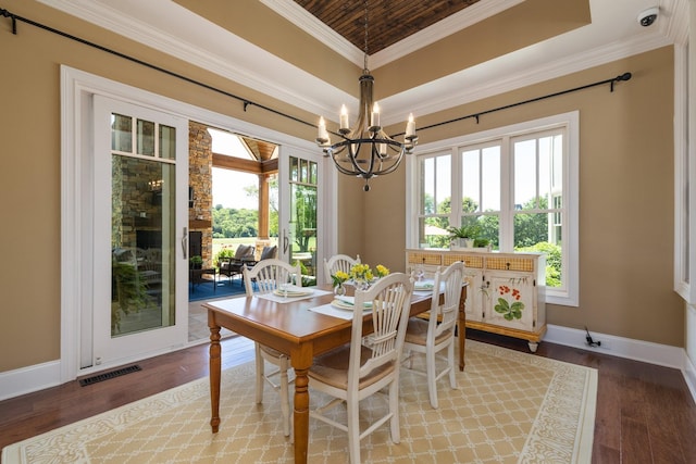 dining area featuring wood ceiling, a tray ceiling, crown molding, a notable chandelier, and hardwood / wood-style floors