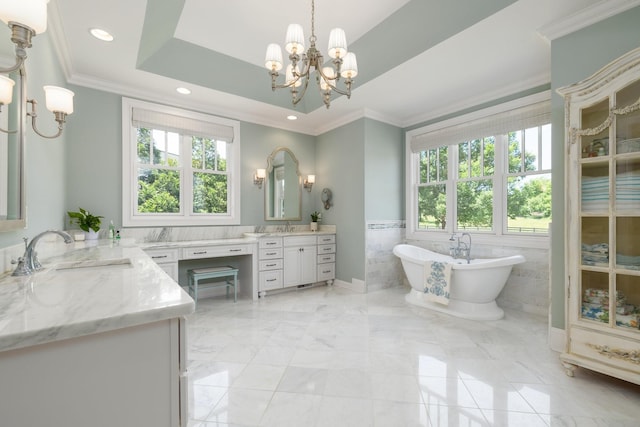 bathroom featuring a wealth of natural light, ornamental molding, vanity, a raised ceiling, and a bath