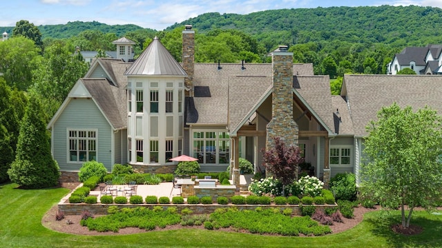 rear view of house featuring a patio area and a yard