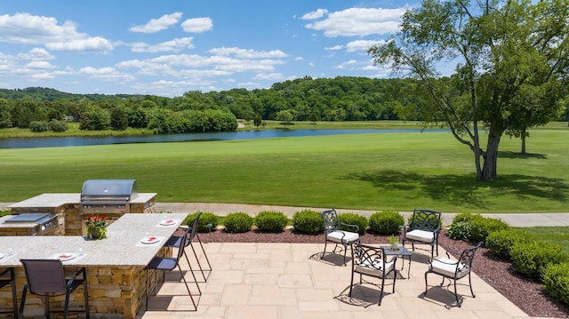 view of patio featuring a water view, area for grilling, a grill, and a bar