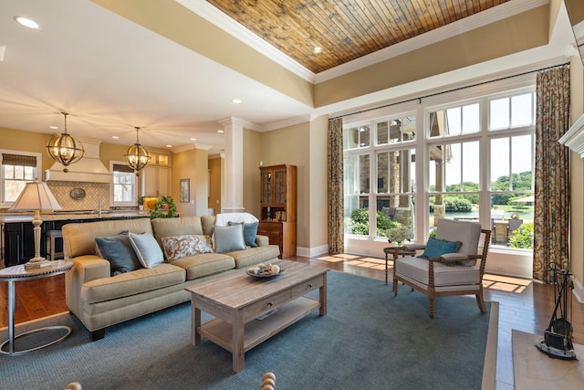 living room featuring ornamental molding, wood-type flooring, wooden ceiling, a chandelier, and a high ceiling