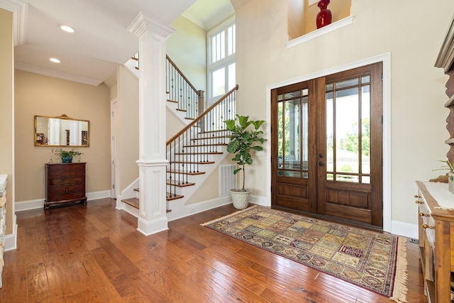 foyer featuring french doors, dark hardwood / wood-style floors, and crown molding