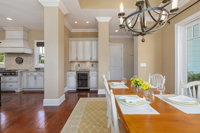 unfurnished dining area featuring a chandelier, wine cooler, dark wood-type flooring, and crown molding