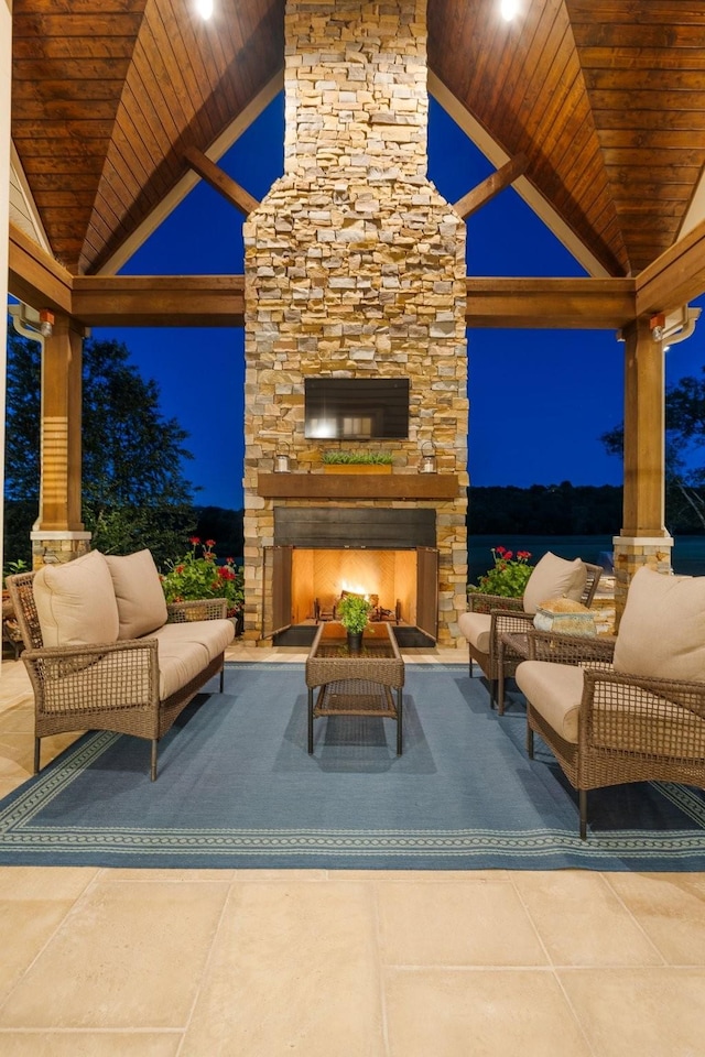 patio at twilight with a gazebo and an outdoor living space with a fireplace