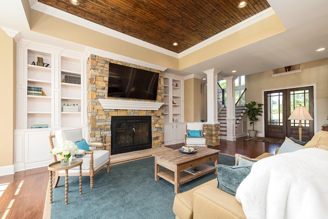 living room featuring built in shelves, wooden ceiling, a raised ceiling, dark hardwood / wood-style floors, and a fireplace