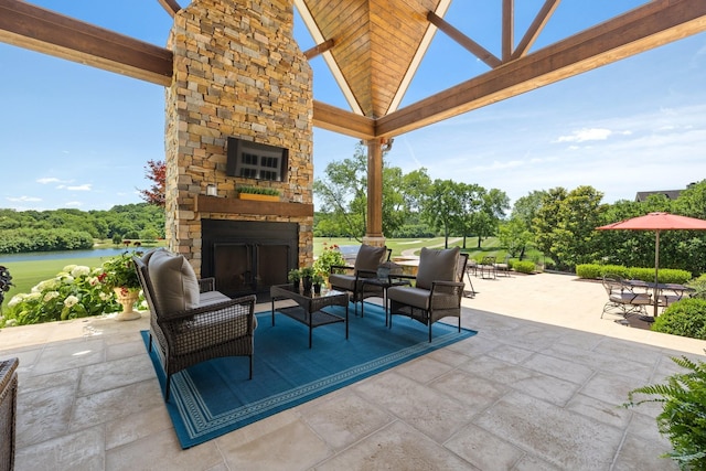 view of patio featuring an outdoor living space with a fireplace, a gazebo, and a water view