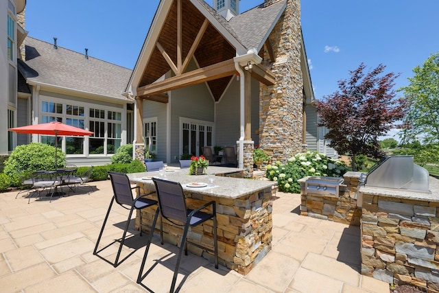 view of patio featuring exterior kitchen and an outdoor bar