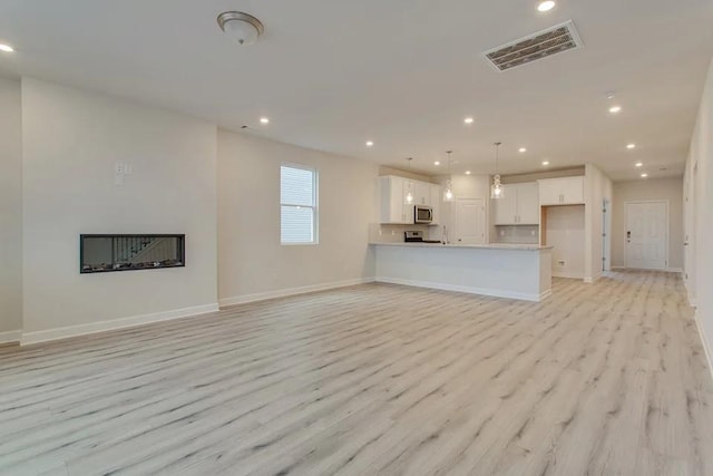 unfurnished living room featuring light hardwood / wood-style floors