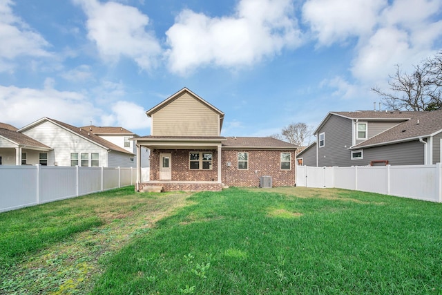 rear view of house with a yard and central AC