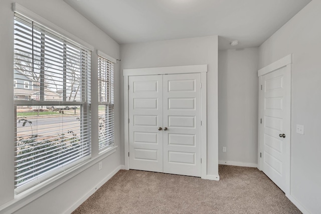 unfurnished bedroom featuring light carpet and a closet