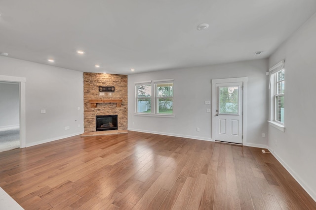 unfurnished living room with a fireplace and light hardwood / wood-style floors