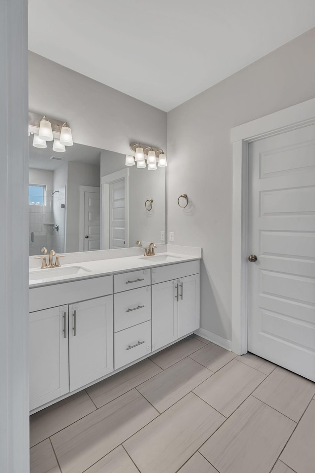 bathroom featuring a tile shower and vanity