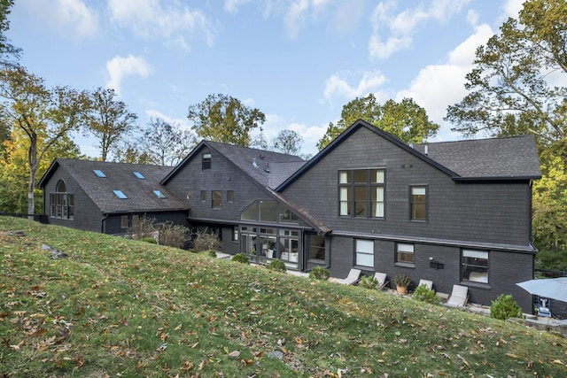 rear view of property with a lawn