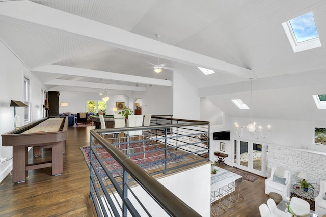 hallway featuring a skylight, dark hardwood / wood-style flooring, beamed ceiling, high vaulted ceiling, and a chandelier