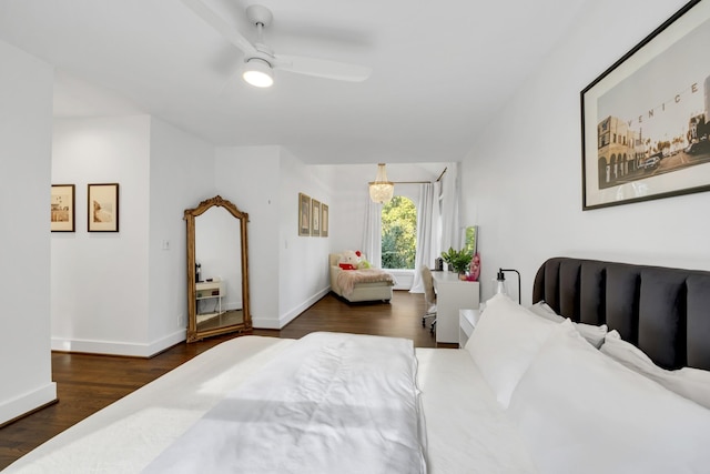 bedroom featuring dark hardwood / wood-style floors and ceiling fan with notable chandelier