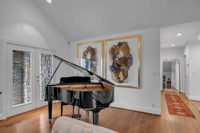 sitting room featuring hardwood / wood-style flooring and high vaulted ceiling