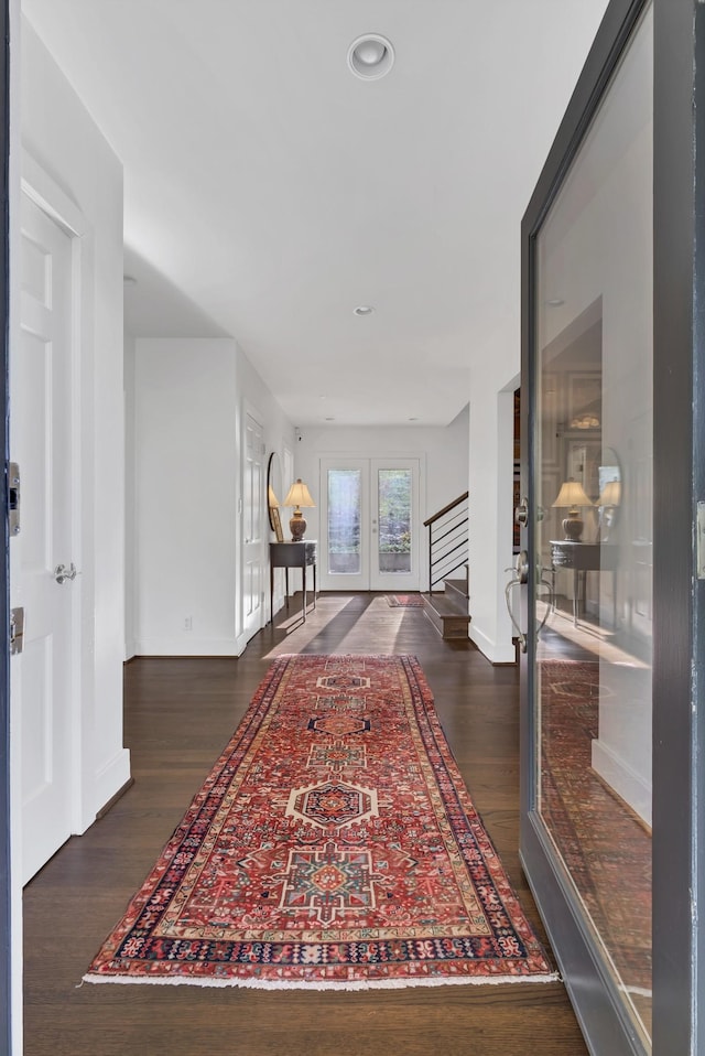 corridor featuring dark hardwood / wood-style flooring and french doors