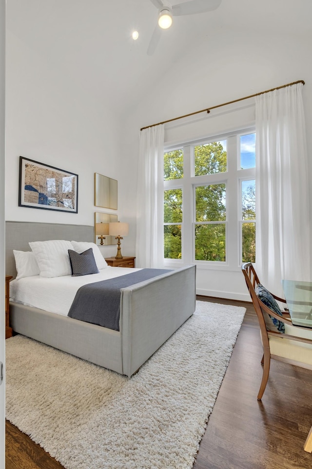 bedroom featuring ceiling fan, dark hardwood / wood-style flooring, and high vaulted ceiling