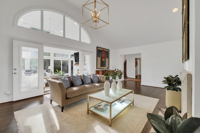 living room with high vaulted ceiling, a chandelier, and hardwood / wood-style flooring