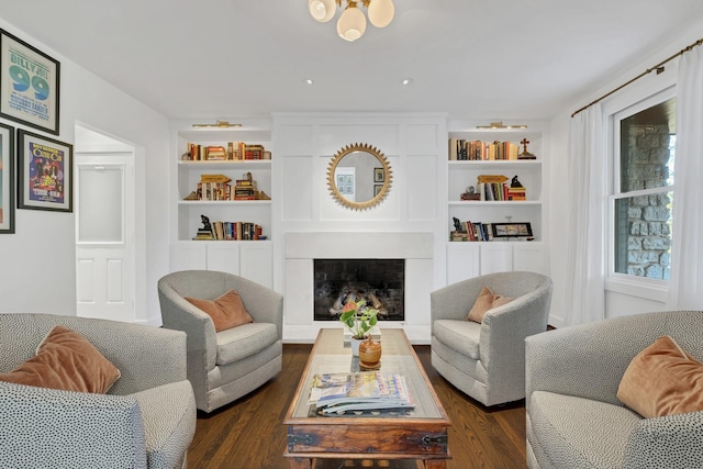 living room with built in shelves and dark hardwood / wood-style floors