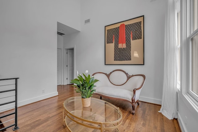 living area featuring hardwood / wood-style floors and a high ceiling