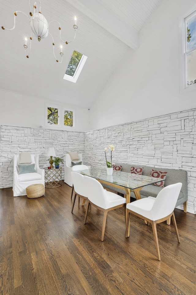 dining space featuring a skylight, beamed ceiling, high vaulted ceiling, breakfast area, and hardwood / wood-style flooring