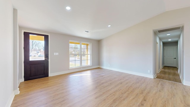 entrance foyer with vaulted ceiling and light hardwood / wood-style flooring