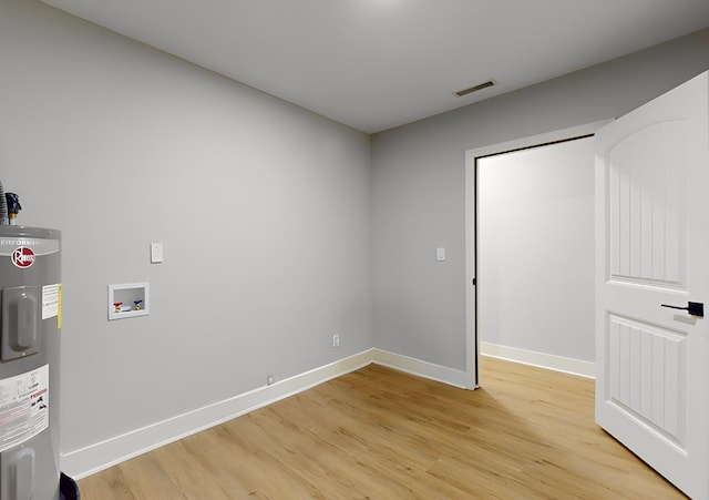 laundry room featuring washer hookup, electric water heater, and light hardwood / wood-style floors