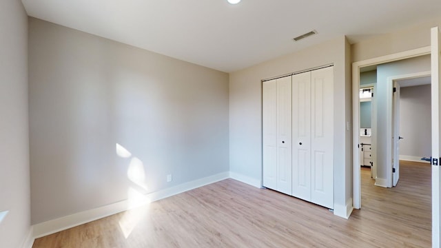 unfurnished bedroom with a closet and light wood-type flooring