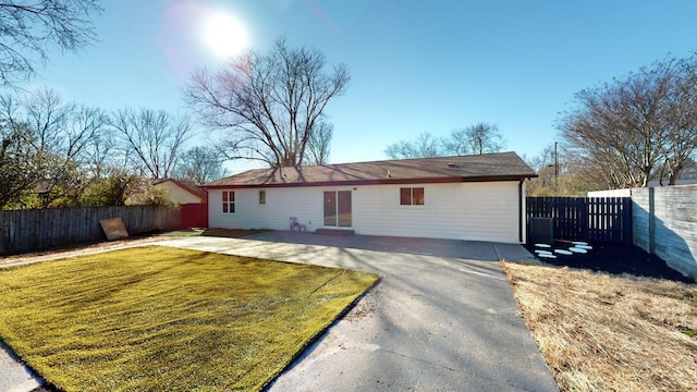 rear view of house featuring a lawn and a patio