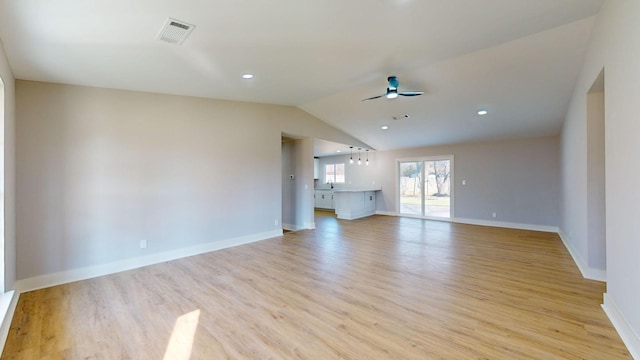 unfurnished living room featuring ceiling fan, sink, light hardwood / wood-style flooring, and vaulted ceiling