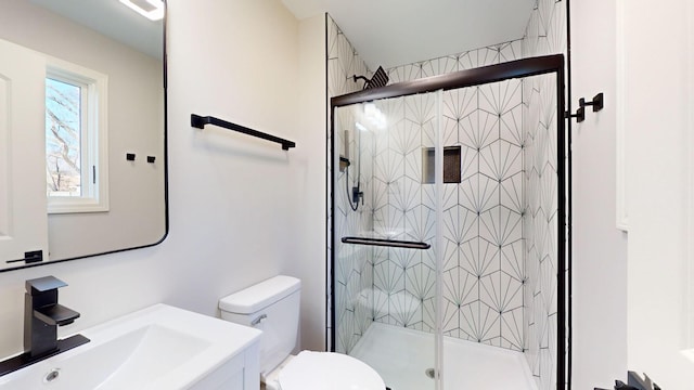 bathroom featuring an enclosed shower, vanity, and toilet