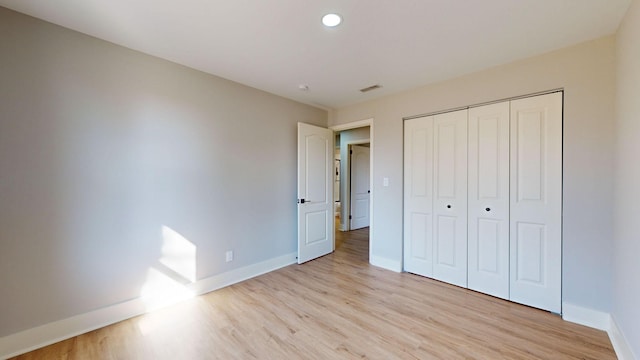 unfurnished bedroom featuring light hardwood / wood-style floors and a closet