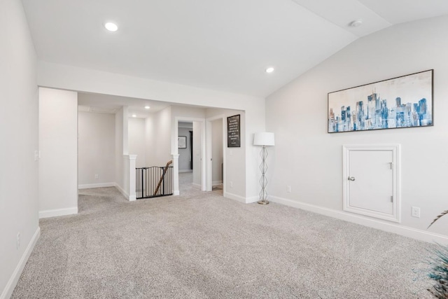 unfurnished room with light carpet and vaulted ceiling