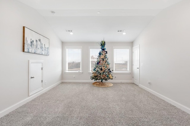 carpeted spare room with lofted ceiling with beams