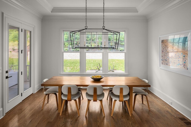 dining room with dark hardwood / wood-style flooring, crown molding, and a tray ceiling