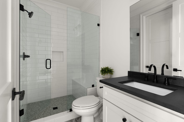 bathroom featuring vanity, toilet, a shower with shower door, and ornamental molding