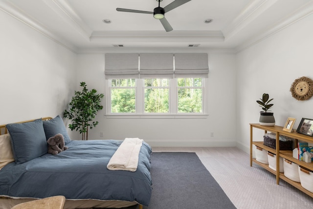 carpeted bedroom with a raised ceiling, ceiling fan, and crown molding