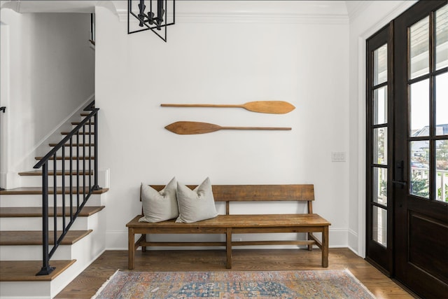 foyer with crown molding, dark hardwood / wood-style flooring, and an inviting chandelier