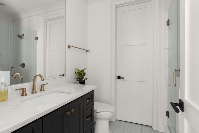 bathroom with crown molding, toilet, vanity, and walk in shower