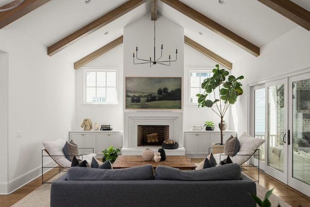 living room featuring lofted ceiling with beams, wood-type flooring, and a chandelier