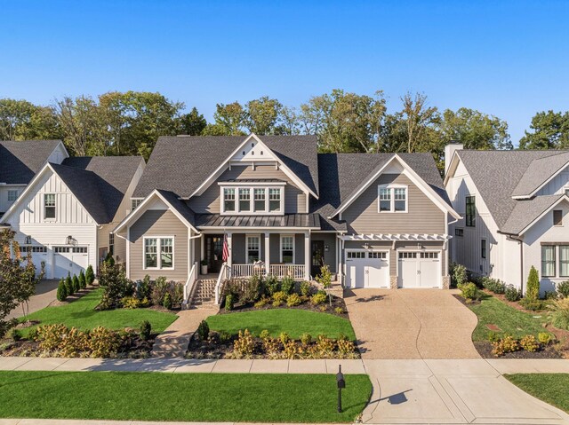 craftsman inspired home featuring a garage, a front lawn, and covered porch