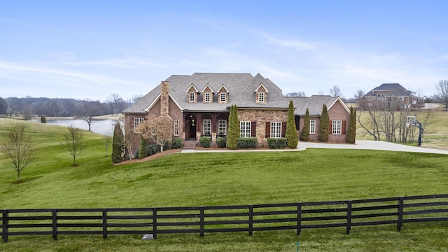 view of front facade featuring a water view and a front lawn