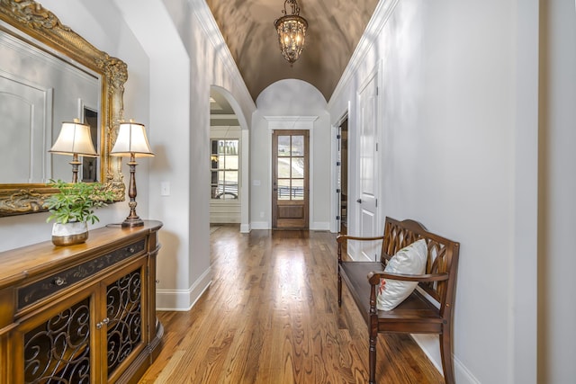 entryway with lofted ceiling, wood-type flooring, and a notable chandelier